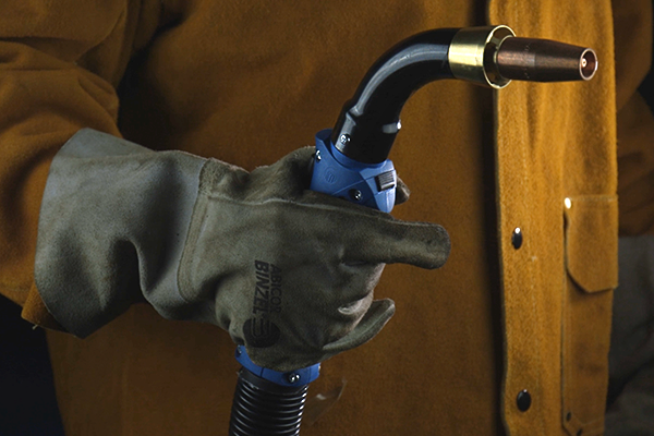 Welder with glove holding MIG fume extraction torch